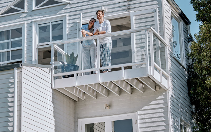 A Couple Looking Outside Their New Home Balcony